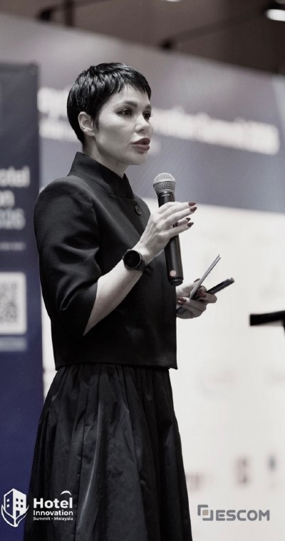 Elise Kotelnikova speaking on stage at the Hotel Innovation Summit